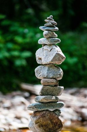Balanced stack of river stones in a serene natural setting, representing calm amid life's challenges